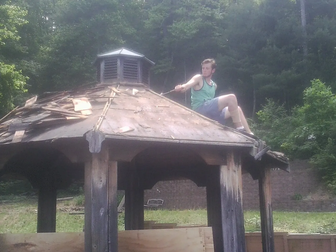 Tearing the old roof off a wooden gazebo before new shakes in Saint Joseph